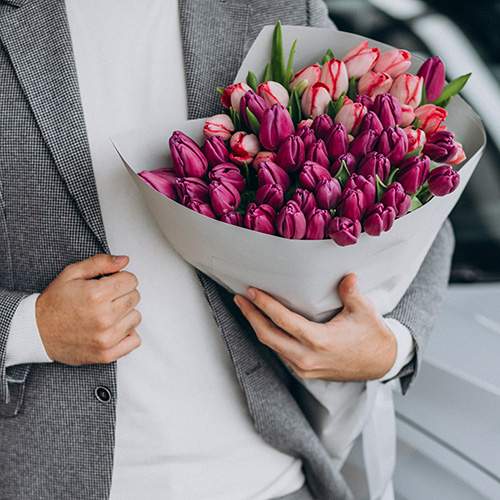 фото чоловіка з букетом тюльпанів